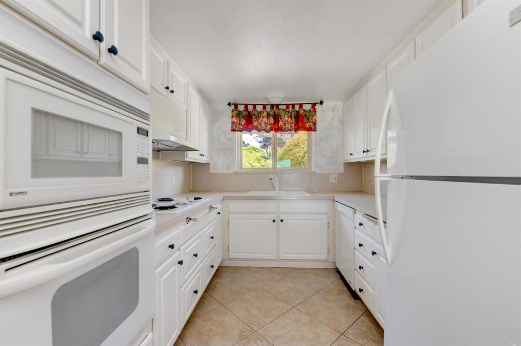 640 West Solana Circle, Unit 1 Solana Beach, CA 92075 - Photo 14 of 42 a kitchen with granite countertop white cabinets and window