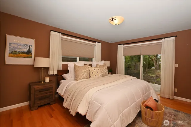 a bedroom with a bed and wooden floor