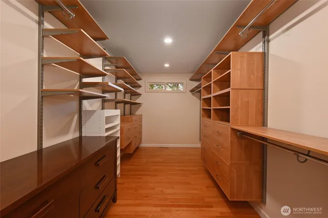 a view of walk in closet with wooden floor