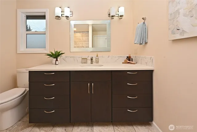 a bathroom with a toilet a sink and mirror
