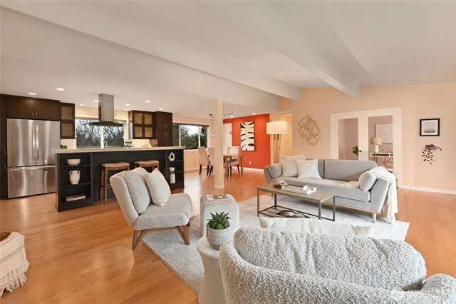 a living room with furniture and a kitchen view