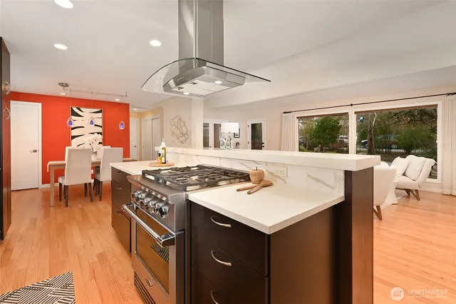 a kitchen with a stove a counter space a sink and dining room view