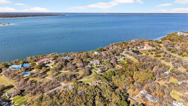 a house that has a big yard with plants and large trees