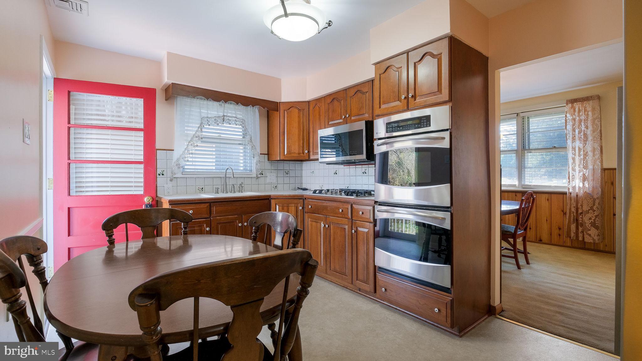 2473 Susquehanna Road Abington, PA 19001 - Photo 12 of 46 a kitchen with stainless steel appliances granite countertop a stove a sink a microwave a dining table and chairs