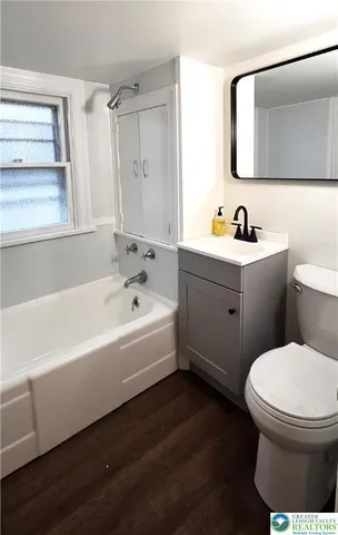 a bathroom with a bathtub sink vanity mirror and toilet