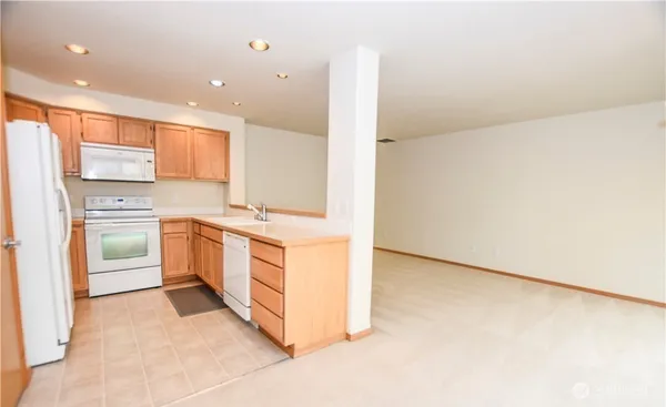 a kitchen with white cabinets and white appliances