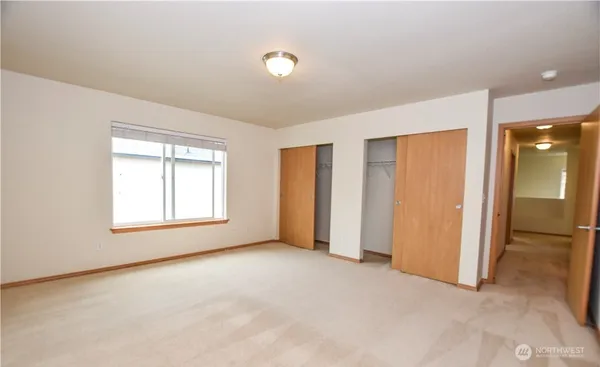 an empty room with windows and closet