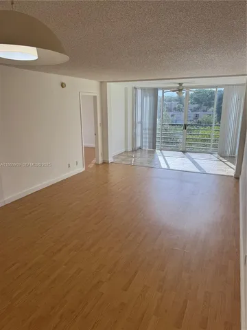 a view of room with wooden floor and windows