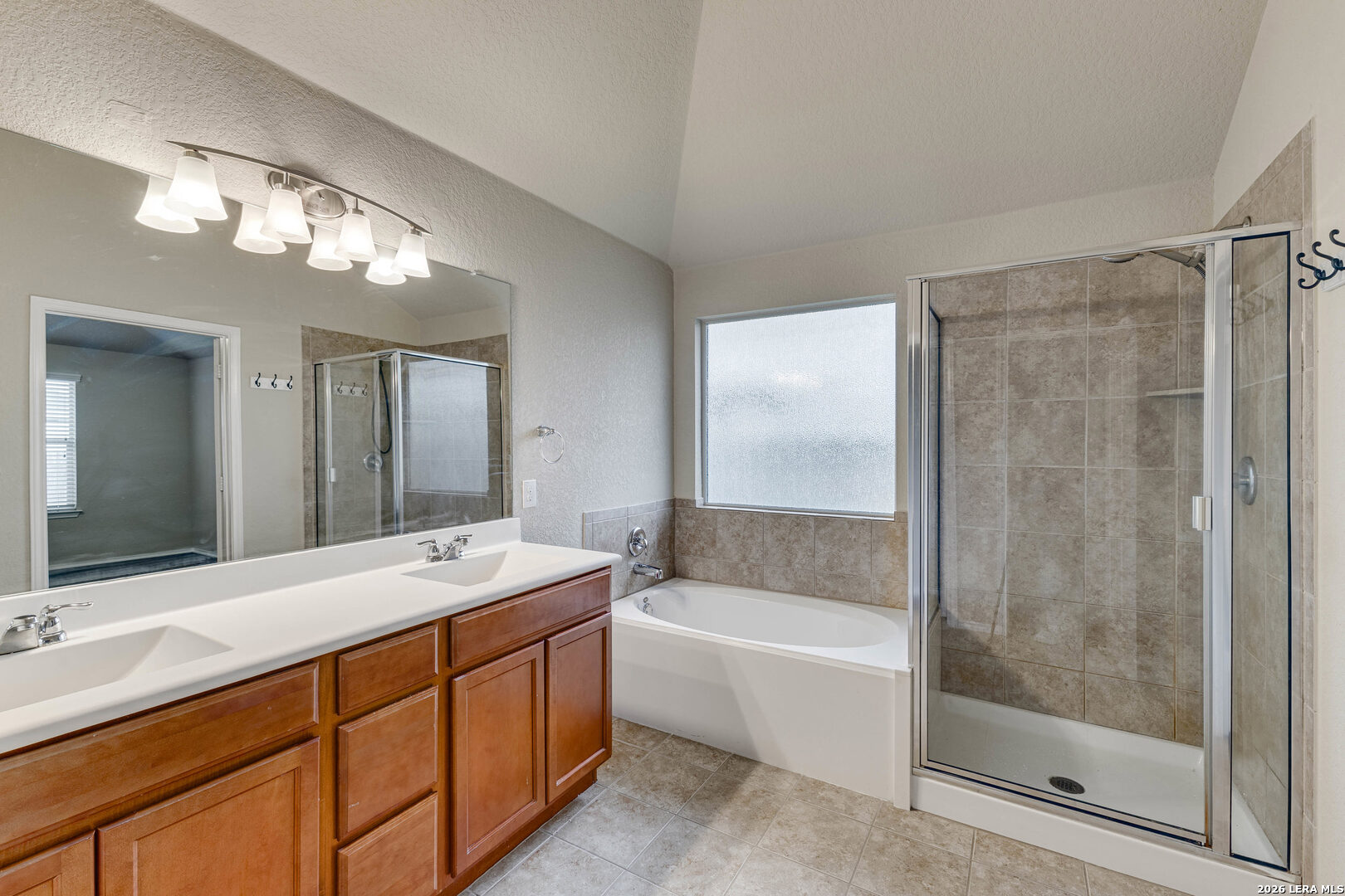 348 Buckboard Lane Cibolo, TX 78108 - Photo 15 of 23 a bathroom with a tub a double vanity sink and a mirror