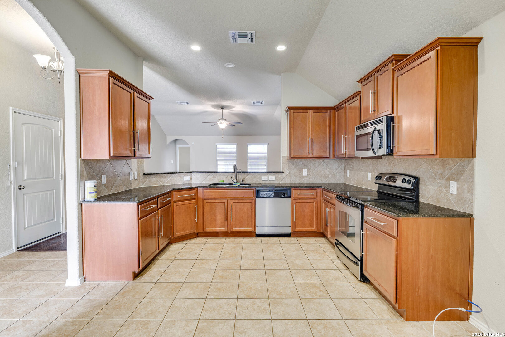 348 Buckboard Lane Cibolo, TX 78108 - Photo 3 of 23 a large kitchen with stainless steel appliances granite countertop a stove granite counter tops and white cabinets