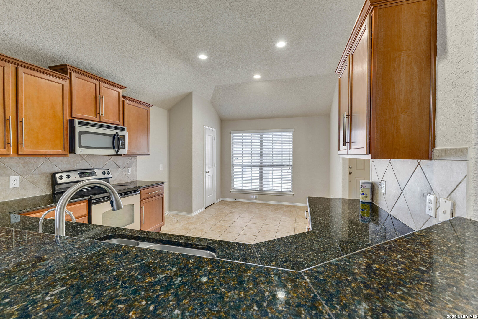 348 Buckboard Lane Cibolo, TX 78108 - Photo 4 of 23 a kitchen with stainless steel appliances granite countertop a sink and a stove