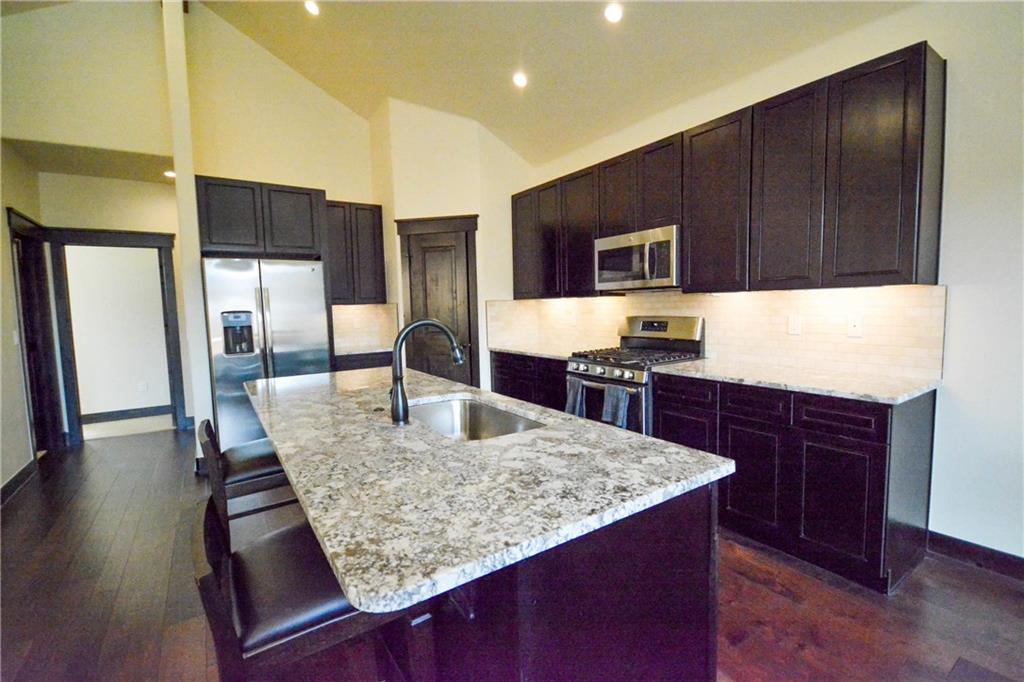 747 Independence Road, Unit 14C Keystone, CO 80435 - Photo 13 of 25 a kitchen with kitchen island granite countertop wooden cabinets dining table and chairs