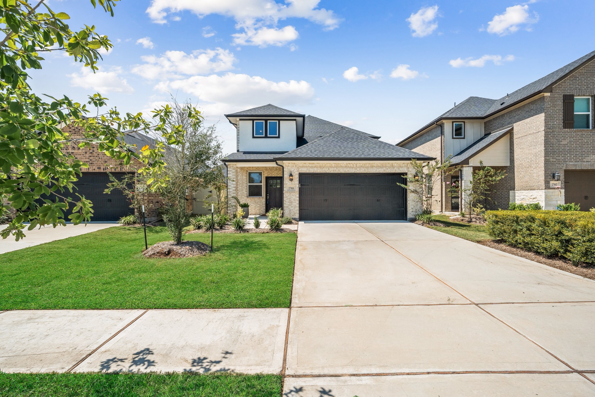 Modern two-story home with a brick exterior, two-car garage, and well-maintained lawn. Spacious driveway and landscaped front yard enhance curb appeal. 