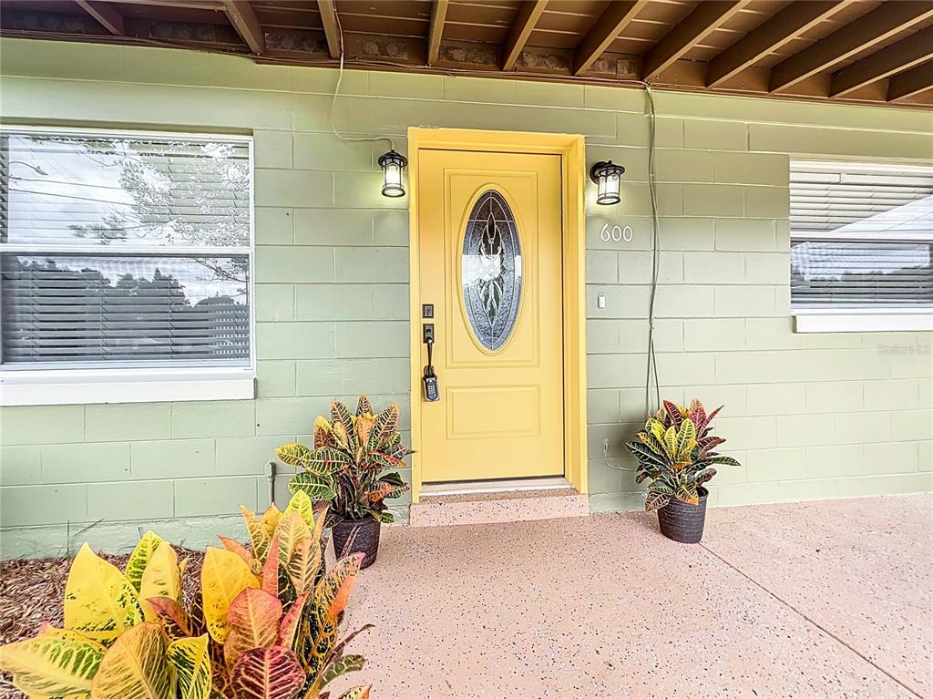 600 Ridgefield Avenue Ocoee, FL 34761 - Photo 2 of 45 Covered front porch and new beveled glass insulated entry door and epoxy painted floor. Notice the new door hardware throughout the house.