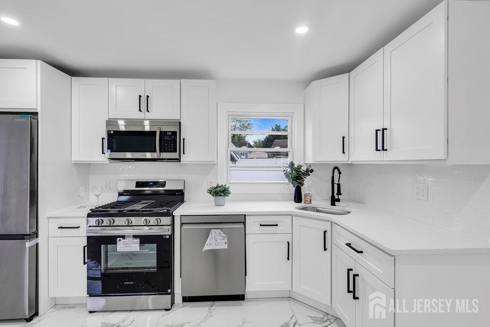 99 Crestview Road Fords, NJ 08863 - Photo 15 of 36 a kitchen with white cabinets and stainless steel appliances