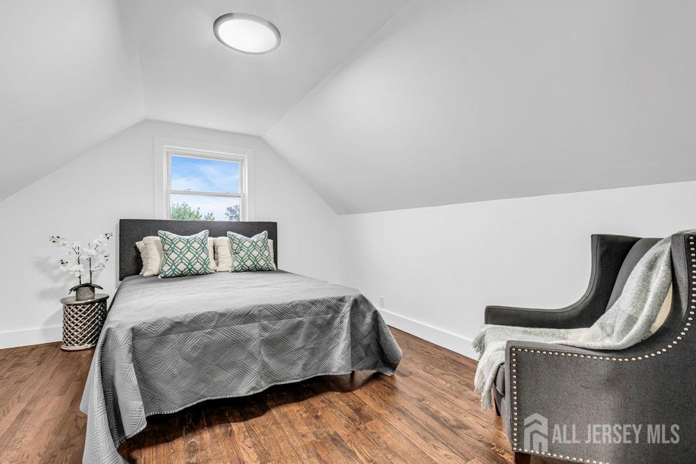 99 Crestview Road Fords, NJ 08863 - Photo 25 of 36 a bedroom with a bed a mirror and a wooden floor