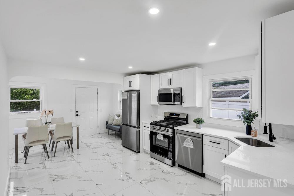 99 Crestview Road Fords, NJ 08863 - Photo 8 of 36 a kitchen with white cabinets and stainless steel appliances