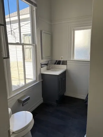 a bathroom with a sink a toilet and a window