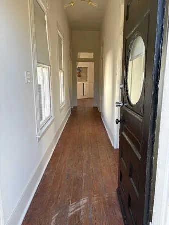 a view of a hallway with wooden floor and entryway