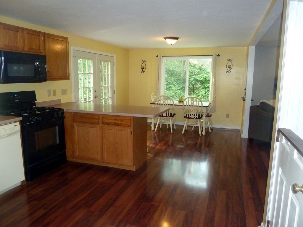 80 Edgewater Road Mashpee, MA 02649 - Photo 15 of 19 a kitchen with wooden floors and wooden cabinets