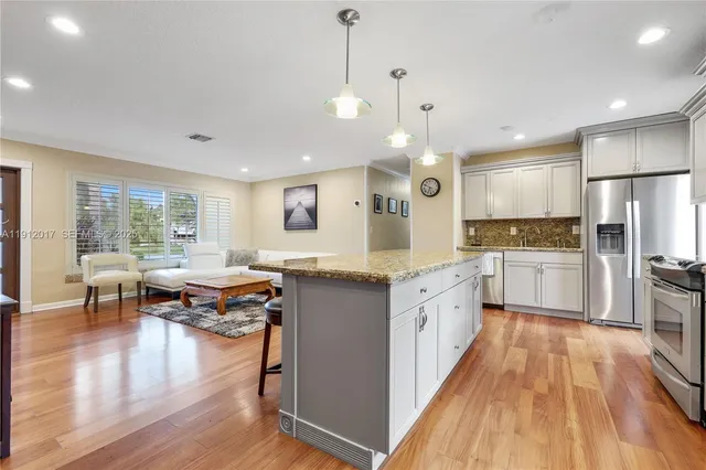 a large kitchen with cabinets wooden floor and stainless steel appliances