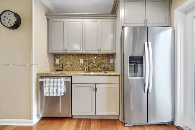 a kitchen with stainless steel appliances granite countertop a refrigerator and a stove top oven