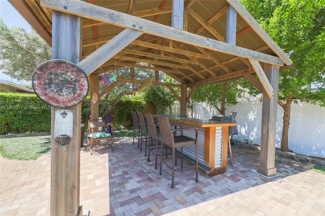 a view of a patio with couches chairs potted plants and palm tree