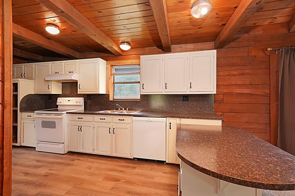 371 Spring Street Forestburg, TX 76239 - Photo 12 of 38 a kitchen with stainless steel appliances granite countertop a stove a sink and white cabinets
