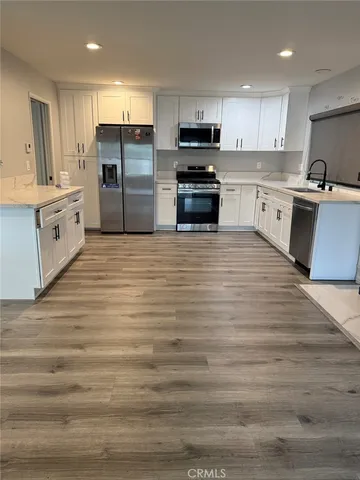 a kitchen with stainless steel appliances a refrigerator sink and cabinets