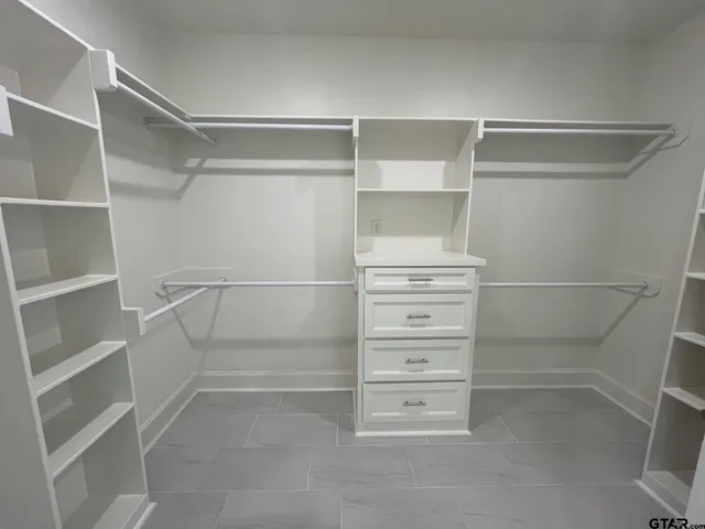 a view of walk in closet with empty racks