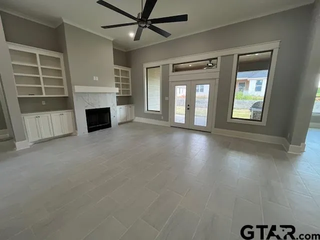 an empty room with windows and fireplace