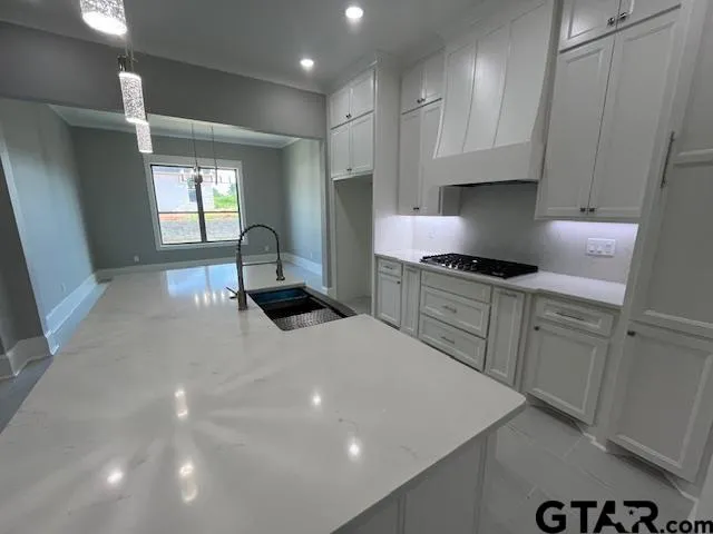 a kitchen with granite countertop a sink a stove and cabinets
