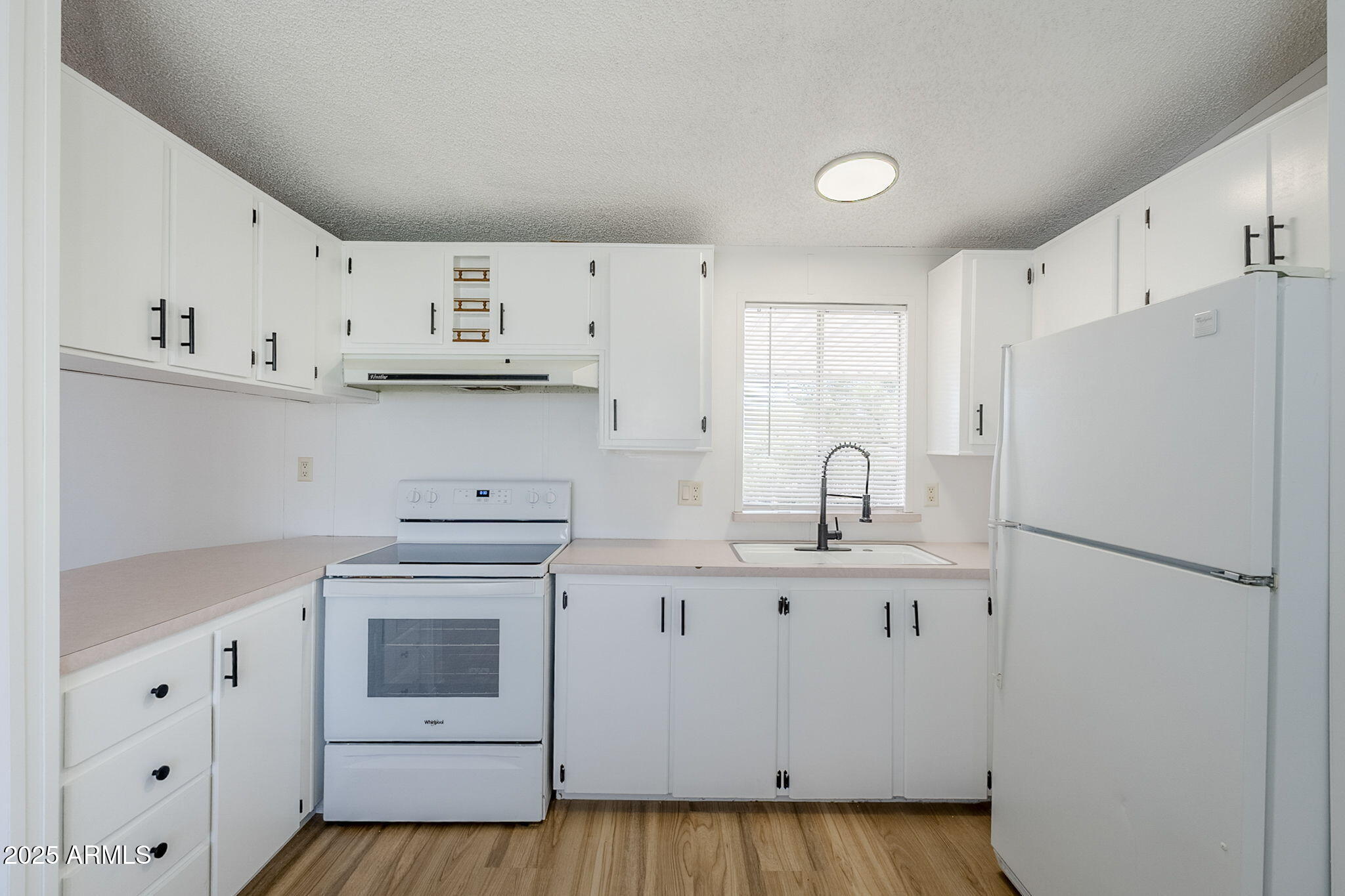 152 Scott Circle Tonto Basin, AZ 85553 - Photo 20 of 51 a kitchen with white cabinets and white appliances