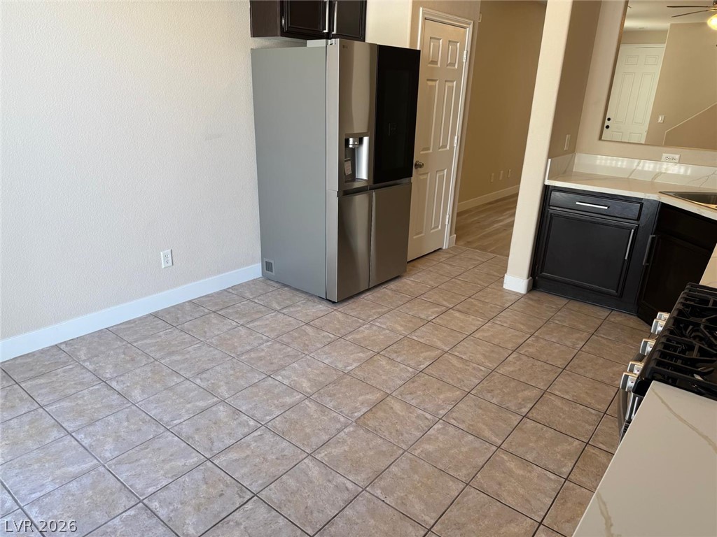 3962 Coyote Ridge Court Las Vegas, NV 89129 - Photo 10 of 35 A contemporary kitchen space boasts sleek stainless steel appliances and durable tile flooring, perfect for modern living.