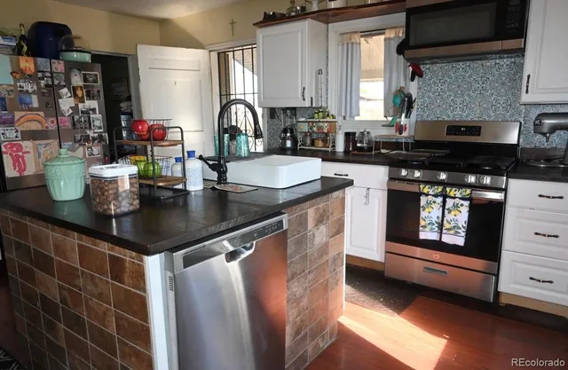 a kitchen with a sink a stove and cabinets