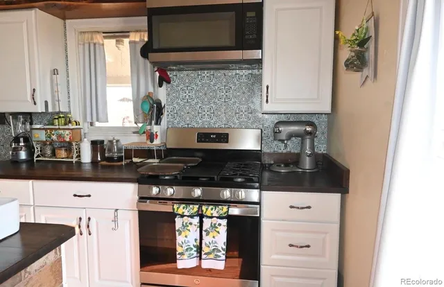 a kitchen with stainless steel appliances granite countertop a stove and a microwave