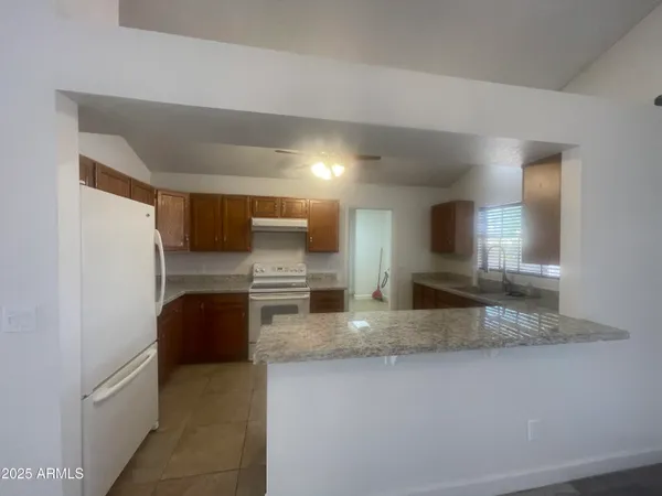 a kitchen with stainless steel appliances granite countertop a sink a stove and a refrigerator