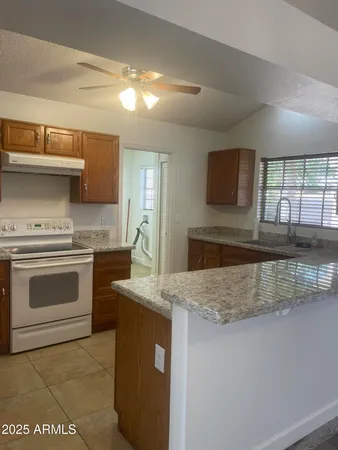 a kitchen with stainless steel appliances granite countertop a stove a sink and a microwave