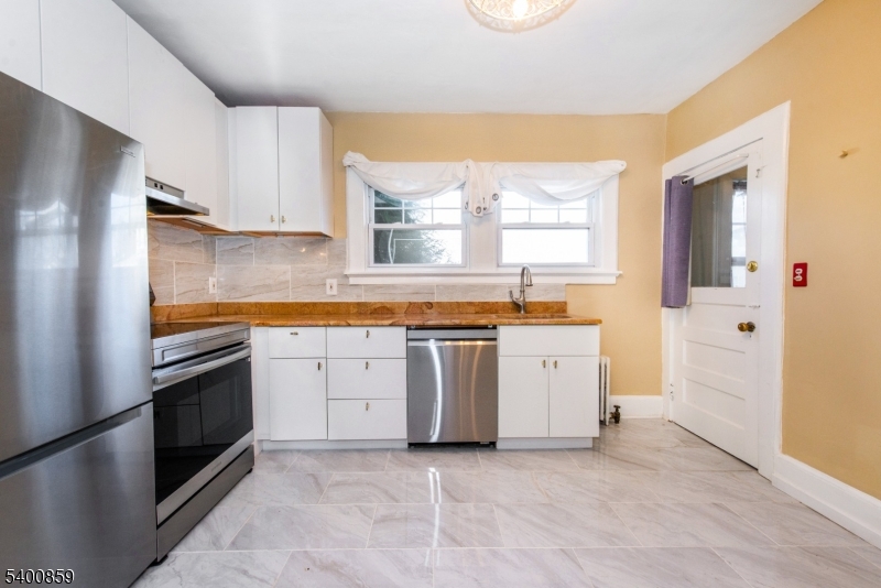 422 Valley Road, Unit 1 Montclair, NJ 07043 - Photo 11 of 24 a kitchen with a stove top oven cabinets and a refrigerator