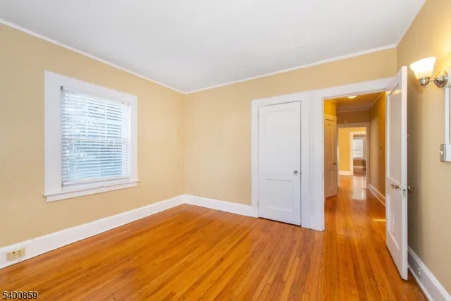 a view of a room with wooden floor and a window