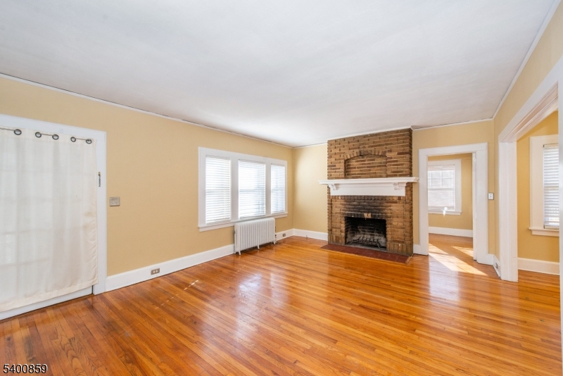 422 Valley Road, Unit 1 Montclair, NJ 07043 - Photo 7 of 24 an empty room with wooden floor fireplace and windows