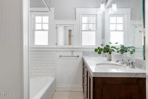 a bathroom with a sink a mirror and a bathtub