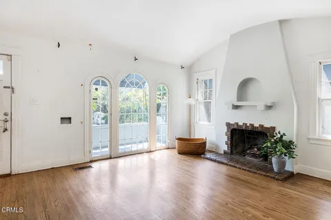 a view of an empty room with window and fire place