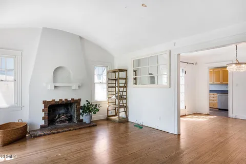 a view of a livingroom with wooden floor and a fireplace