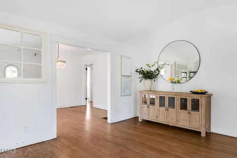 a view of a bedroom with wooden floor and windows