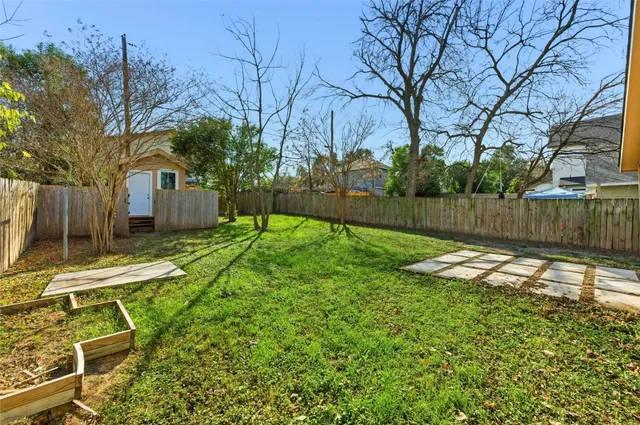 a view of a backyard with a table and chair and wooden fence