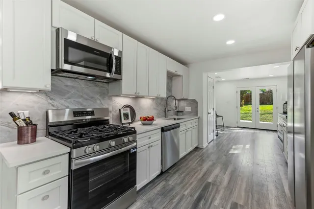 a kitchen with stainless steel appliances a stove a microwave and cabinets