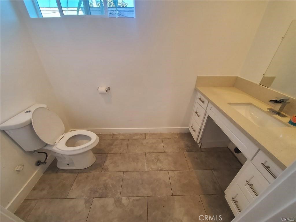 437 North Fries Avenue, Unit 1 Wilmington, CA 90744 - Photo 14 of 14 a bathroom with a granite countertop toilet and a sink