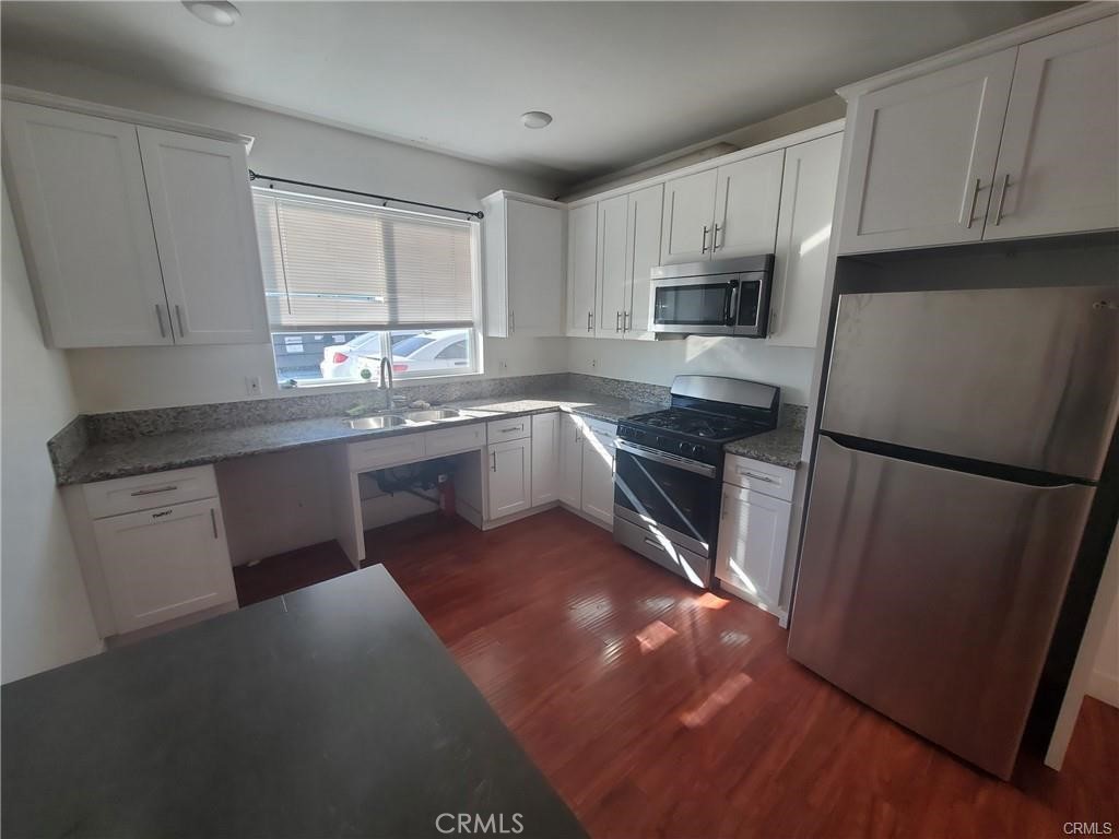 437 North Fries Avenue, Unit 1 Wilmington, CA 90744 - Photo 6 of 14 a kitchen with stainless steel appliances granite countertop a refrigerator a sink a stove a microwave and island