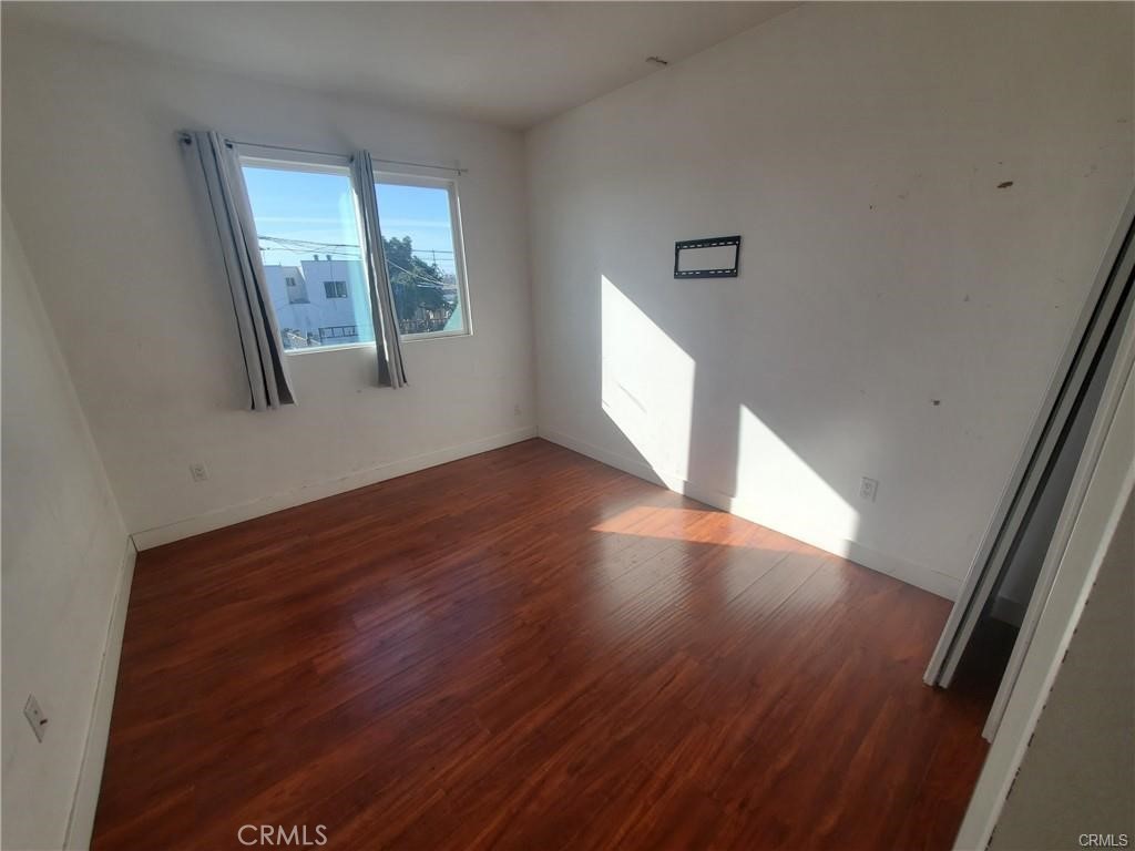 437 North Fries Avenue, Unit 1 Wilmington, CA 90744 - Photo 9 of 14 a view of an empty room with wooden floor and a window